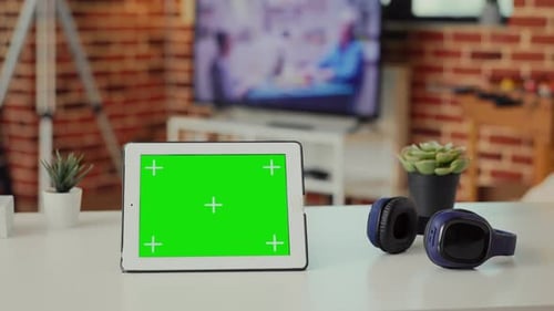 Empty Desk with Digital Tablet Showing Green Screen on Display