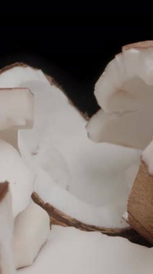 Vertical video. The Camera Approaches Coconut Pieces Scattered on the Table and Moves Through Them.