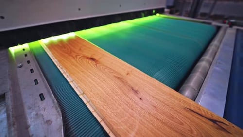 Parquet factory. Wooden laminate board moving on a conveyor line inside the modern industrial plant.