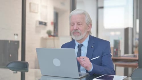 Man in Suit Talking on Laptop Video Call