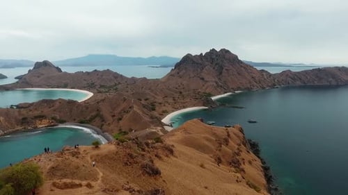 Aerial view of hikers on top of the Padar island, overcast day, in Komodo, Indonesia - circling, dro