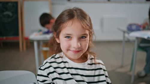 Smiling Pupil Girl Looking Camera Sitting Lesson in School Classroom Portrait