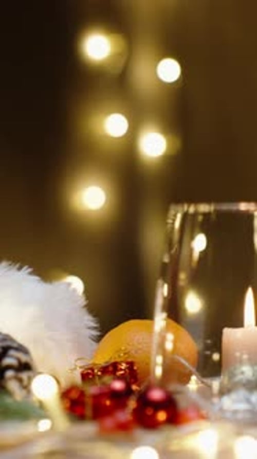 Vertical video. Christmas table with scattered decorations, candles and garlands. I put a bar of cho