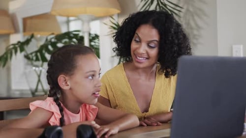 Child and Adult Communicate with Laptop Indoors