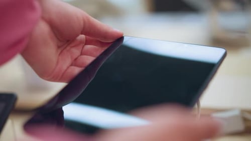 Dame mit Tablet im Elektronikgeschäft beobachtet Bildschirmreflexion