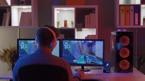 Adult Playing Video Game on Dual Monitors