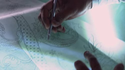 Fashion Designer Sketching And Drafting Clothing Design Concepts In A Textiles Studio.