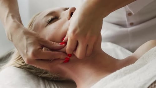 Woman Receiving Relaxing Facial Massage at Spa