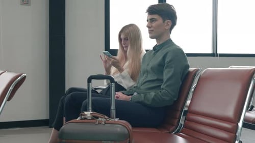 Passenger traveler people with luggage suitcase sitting on airport chair waiting for air travel