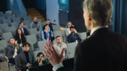 Back View of Organization Representative Pronouncing Speech in the Conference Room