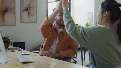 Programadores multiétnicos masculinos e femininos dando cumprimentos na conclusão do projeto
