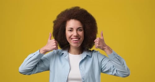 Woman Smiling and Giving Two Thumbs Up