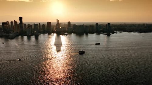 Silhouettes of skyscrapers standing above the river and reflecting in the water. New York skyline