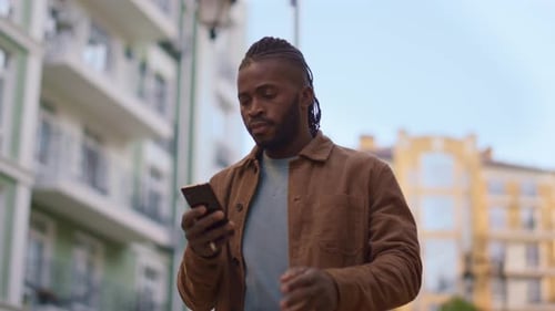 Man Walks and Talks on Phone in City