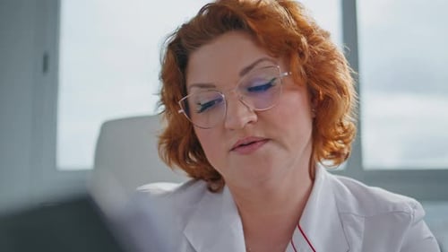 Healthcare Provider Reading Document at Medical Examination Clinic Closeup