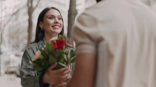 Smiling Woman Receiving Gifts and Flowers Outdoors