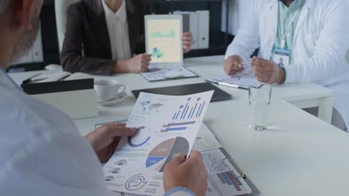 Professionals Analyzing Charts in Business Meeting