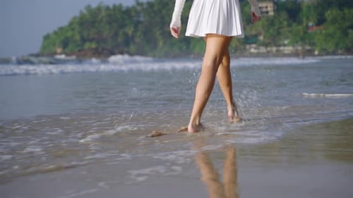Female Feet Walking and Making Splashes in Sea Surf Waves Person's Legs Running and Jumping Along