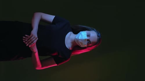 Young Woman Wearing Face Mask in Dramatic Lighting