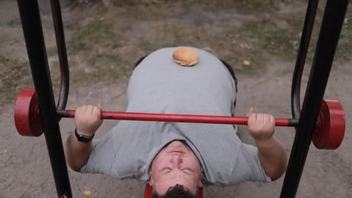 Man Lifts Weights With Burger Bun on Stomach