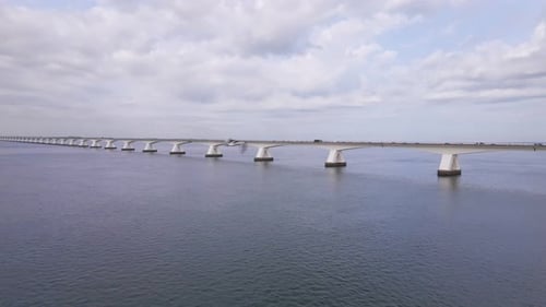 beautiful drone flight over the water from the eastern schelde to the Zeeland bridge under a cloudy