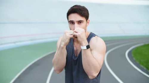 Sport Man Boxing at Stadium. Male Runner Warming Up Before Workout Outdoor