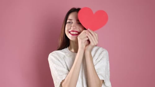 St. Valentine's Day. Woman with paper heart on pink background