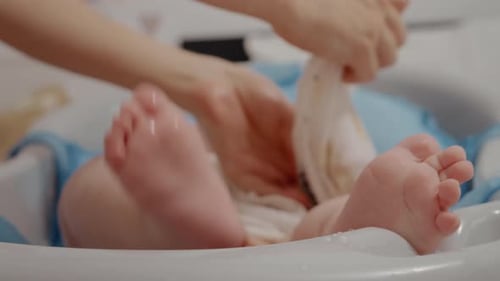 Baby Gets Washed in Small White Bathtub