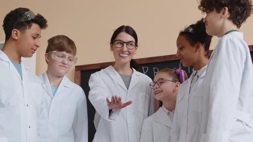 Students and Teacher Stack Hands in Science Classroom