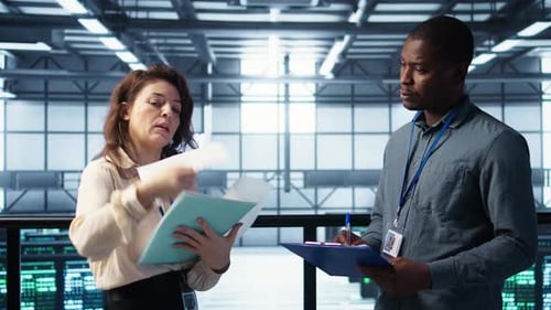 Colleagues Discussing Server Data in Modern Data Center