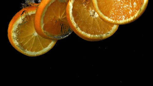 Orange Slices Falling Under Water on a Black Background Filmed on a Highspeed Camera at 1000 Fps