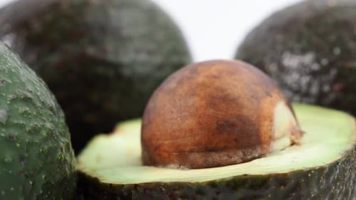 Frische Avocados rotieren auf weißem Hintergrund.