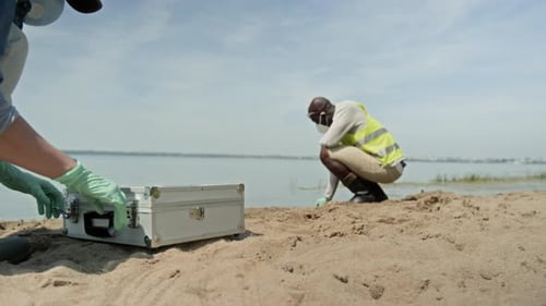 Environmental Scientists Taking Water Samples from Lake