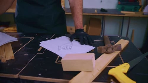 Carpintero dibujando un boceto de muebles en un banco de trabajo
