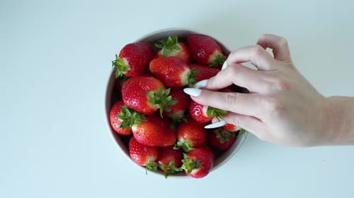 Fresh Strawberries in a Bowl with Hand