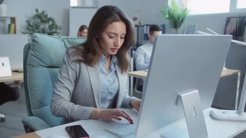 In Modern Office Young Businesswoman Working Typing on Laptop Computer On Background People Working