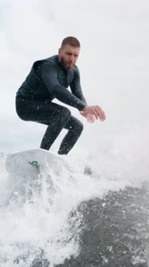 A Skilled Surfer Captures the Essence of Thrilling Ocean Waves with Dynamic Movements and Impressive