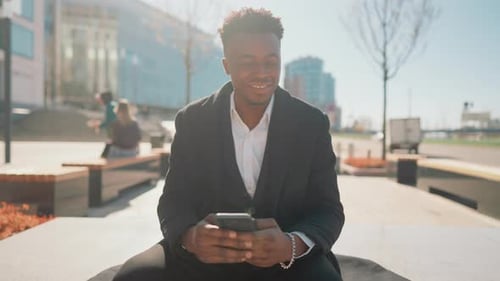 Portrait of Positive Black Man with Modern Smartphone on Street in Sunny Day African American Male