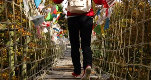 Older women with backpack passing Himalayan sidewalk path Skywalk wooden construction with colored f