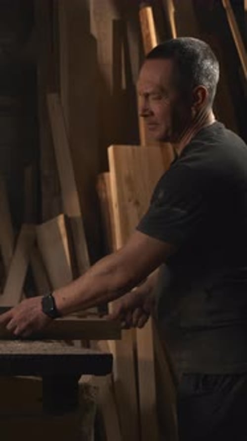 Worker With Smile Joyful Craftsman In Welllit Workshop Carefully Guiding Long Piece Of Wood Through