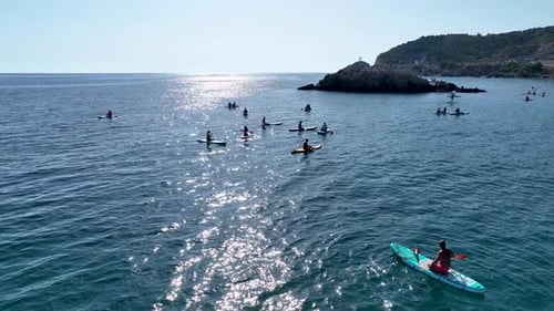 Aerial View Group Paddleboarding in the Calm Waters of Mediterranean Lagoon