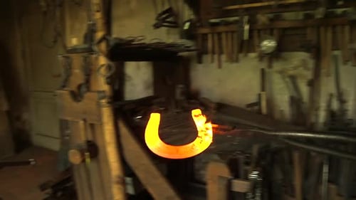 Blacksmith Removing Glowing Hot Horseshoe From Fire
