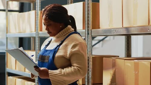 Woman Taking Inventory Notes in Warehouse