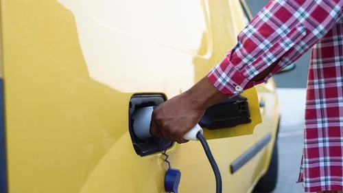 Unrecognizable Black Man Unplugs Charging Cable Electric Vehicle Green Energy Eco Friendly Fuel Male