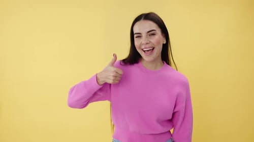 Happy Woman Gives Two Thumbs Up on Yellow