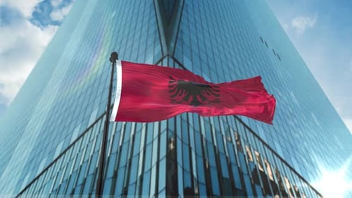 Albania Flag Waving in Front of Modern Corporate Building
