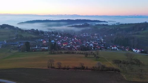 Highways Pass Through Valley with Forests Meadows and Village Shrouded in Mist in Evening Light