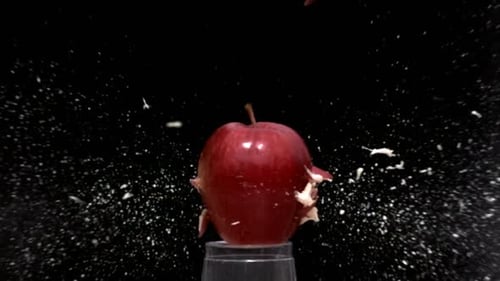 Red Apple Shatters on Glass Stand in Slow Motion
