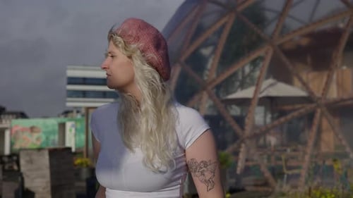 Woman Walks Through an Urban Rooftop Garden