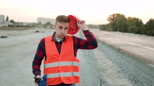 Tired Busy Builder Takes Off Helmet and Walk